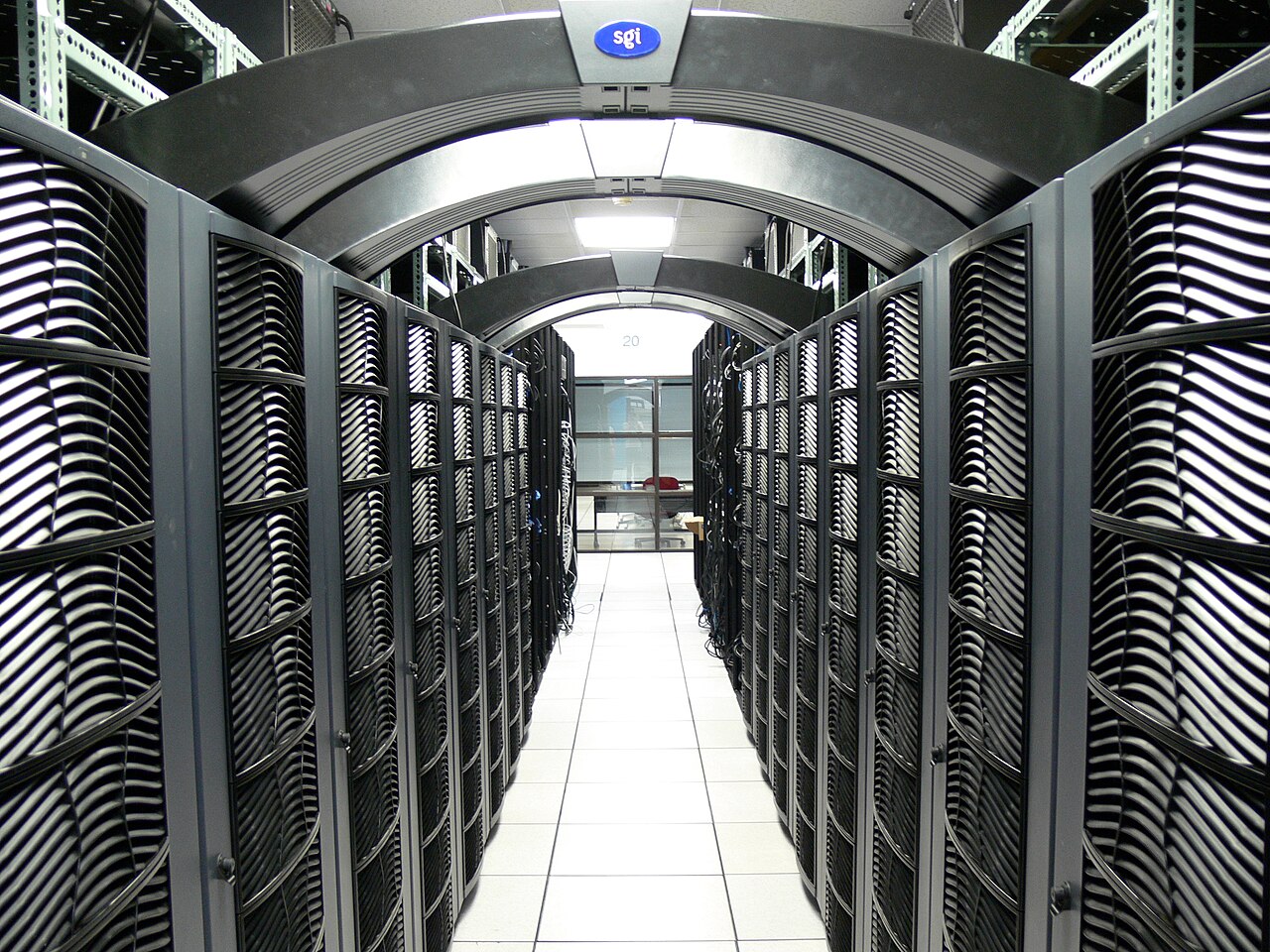 Rows of black server racks with blinking lights in a data center.